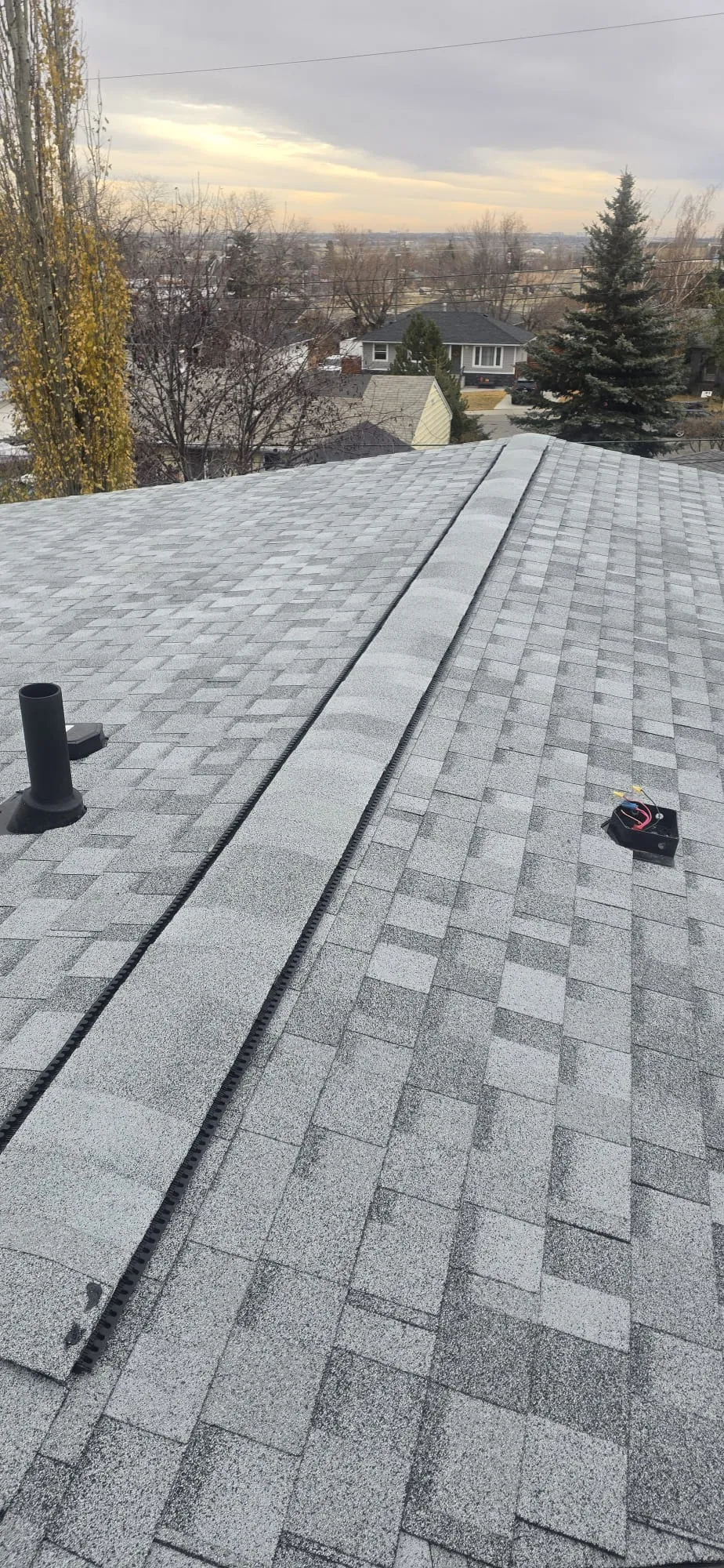 Asphalt shingle roof ridge vent plumbing boot in Calgary