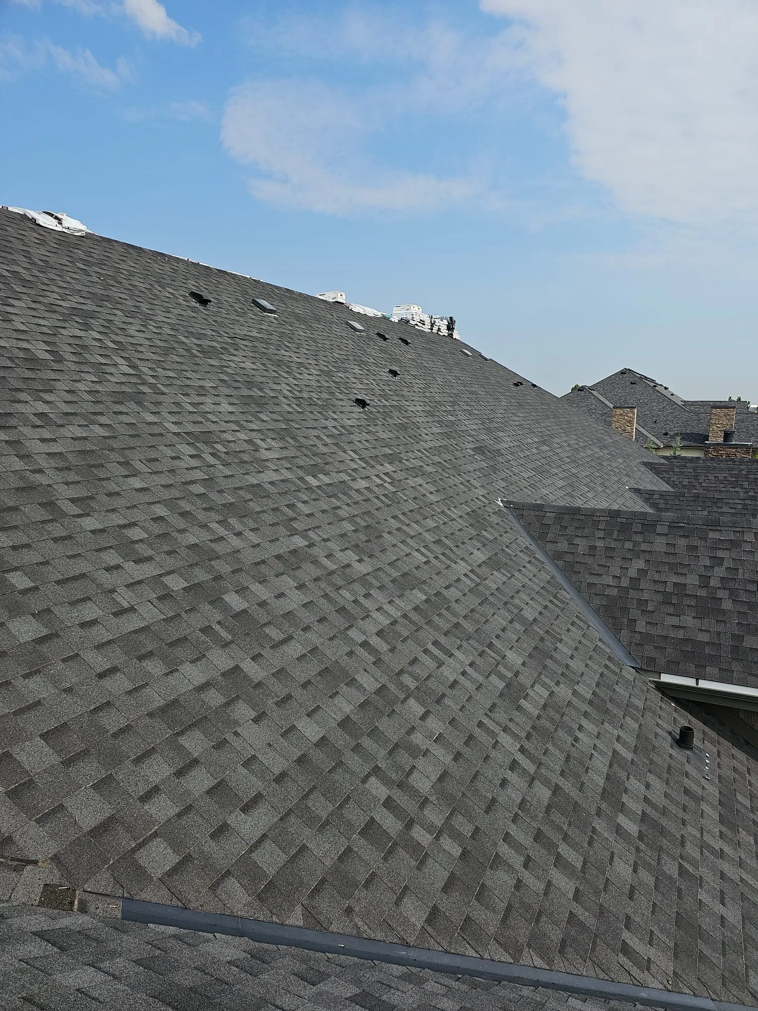 Dark grey shingle roof installation in Calgary